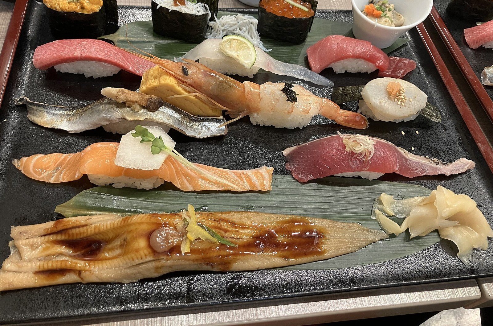 Un plateau de nigiri : thon gras, crevette, saumon, anguille grillée, oursin et œufs de saumon