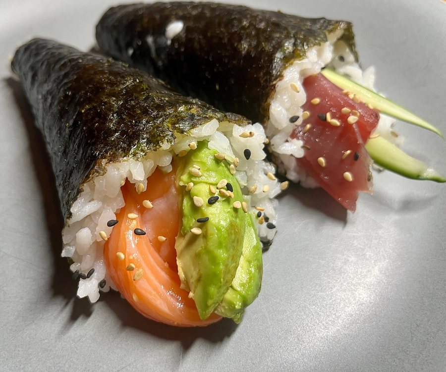 Deux cornets de nori garnis de riz, l’un de saumon et d’avocat, l’autre de thon et de concombre